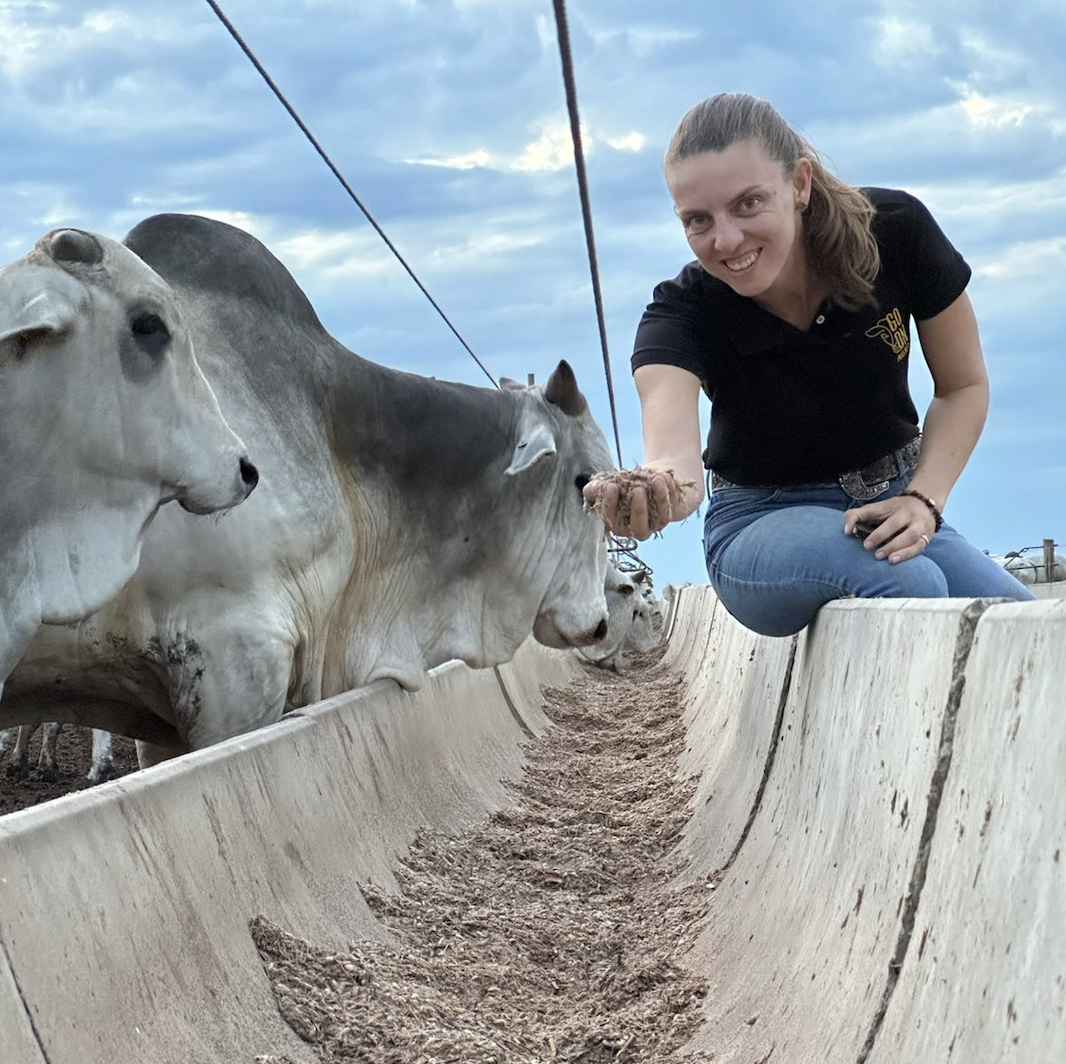 Renata Erler ao lado do gado, sorrindo para a câmera